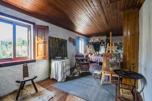 a room with a wooden ceiling and a table and chairs at A casinha in Vila Nova de Anços