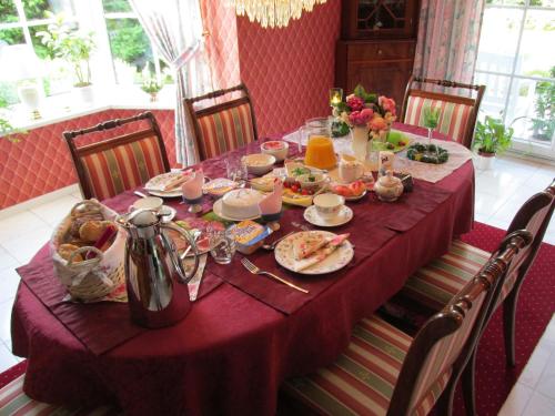 einen Esstisch mit einem lila Tischtuch in der Unterkunft Pension Roseneck in Wolfshagen
