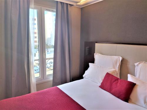 1 dormitorio con cama blanca y ventana en Cactus, en París