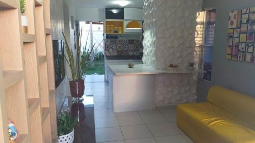 eine Küche mit einem gelben Sofa in einem Zimmer in der Unterkunft Casa em Condomínio Fechado na Praia do Francês in Marechal Deodoro