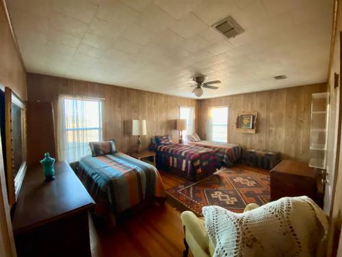 een woonkamer met 2 bedden en een bank bij The White House at SF Ranch in Comanche