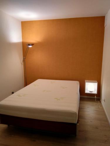 a bedroom with a bed and a brown wall at Residentie Romanza in Middelkerke