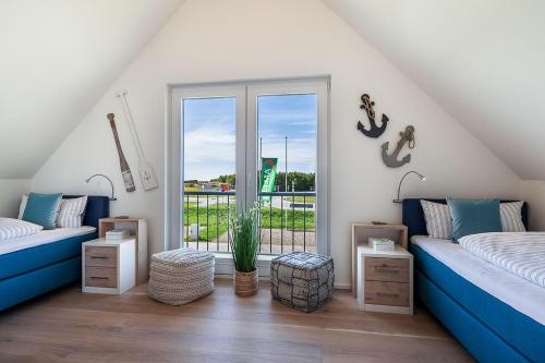 ein Wohnzimmer mit 2 Betten und einem Fenster in der Unterkunft NordseeResort Büsum Ferienhaus 1 Beach House in Büsum