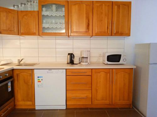 a kitchen with wooden cabinets and a white refrigerator at Apartman Josipa in Peroj