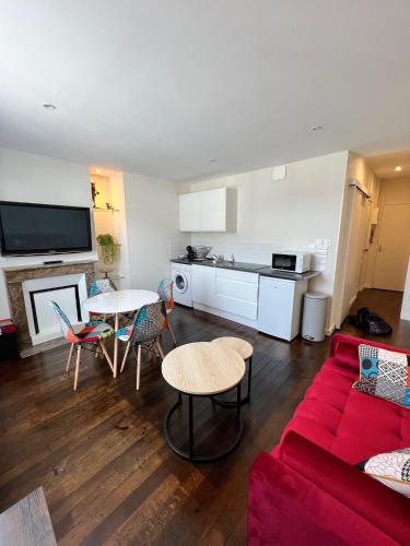 un salon avec un canapé rouge et une table dans l'établissement Lysbed - Le Pilori, à Angers