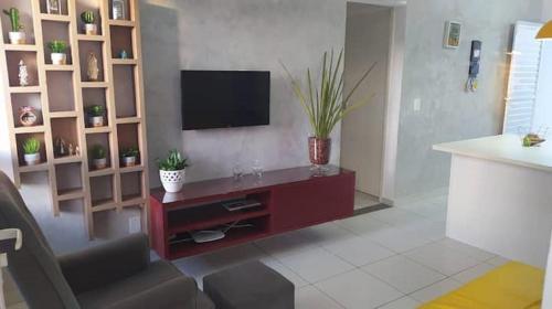 a living room with a flat screen tv on a wall at Casa com Piscina em Condomínio Fechado na Praia do Francês in Marechal Deodoro