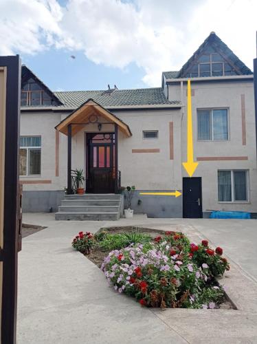 a house with a bunch of flowers in front of it at Julia's Place - Apartment, Garden & BBQ in Vagharshapat