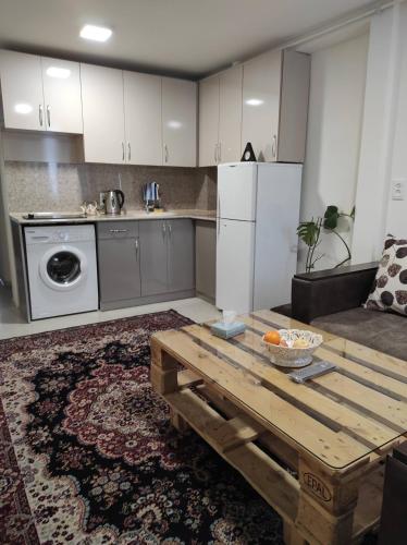 a kitchen with a wooden table and a refrigerator at Julia's Place - Apartment, Garden & BBQ in Vagharshapat