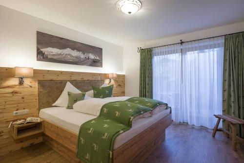 a bedroom with a large bed and a window at Alpenresidenz Unterrainer in Ellmau