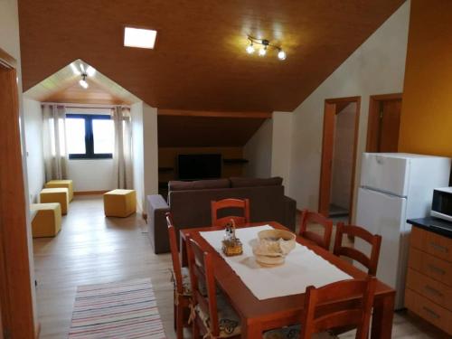 a kitchen and living room with a table and chairs at Recantos do Castanheiro in Porto Moniz