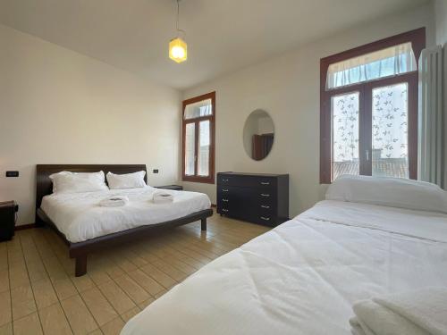 孔塞爾韋的住宿－Blue Apartment Conselve，一间卧室配有两张床和镜子