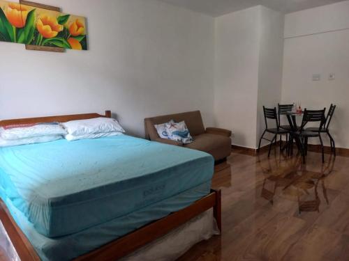 a bedroom with a bed and a living room with a couch at cantinho do Xavier in São Vicente