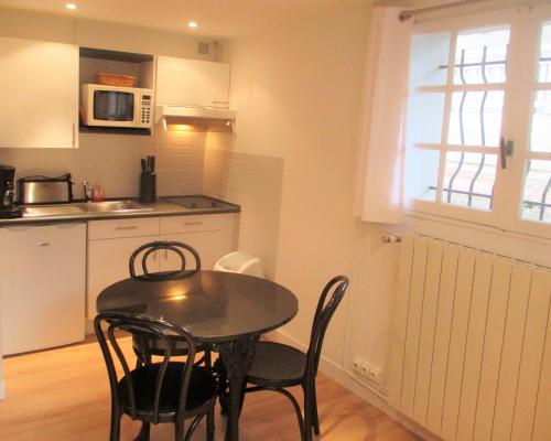 une cuisine avec une table et des chaises dans une pièce dans l'établissement Cosy studio au cœur du triangle d'or, à Le Touquet-Paris-Plage