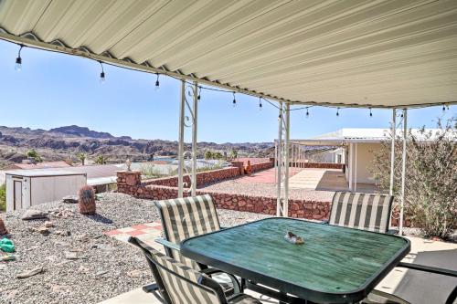 a patio with a green table and two chairs at Sun-Dappled AZ Abode with River and Mtn Views! in Parker