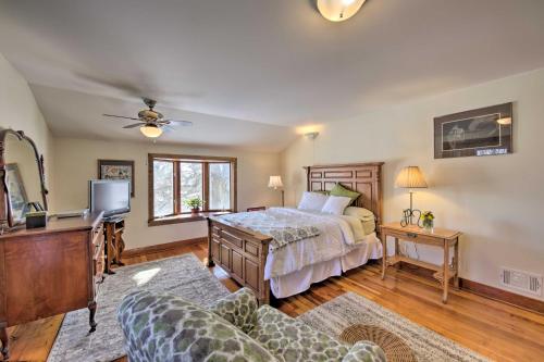 Un dormitorio con una cama, un televisor y un sofá. en Quaint and Family-Friendly Watertown Farmhouse!, en Watertown