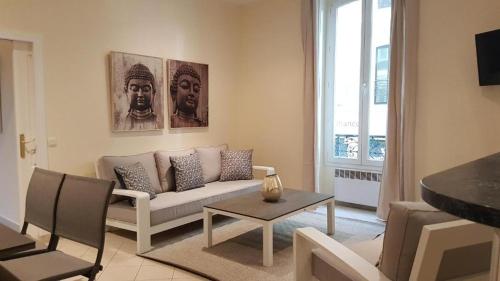 een woonkamer met een bank en een tafel bij Aston - Appartement Centre Ville Massena in Nice
