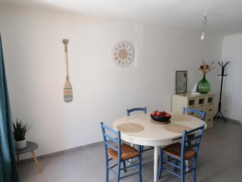 - une table blanche avec des chaises et un bol de fruits dans l'établissement Appartement SÈTE LA CORNICHE - 4 PERSONNES, à Sète