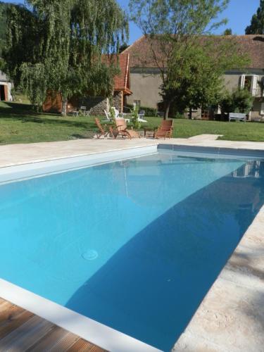 a large blue swimming pool in front of a house at Chambre LA LONGERE in Treffort