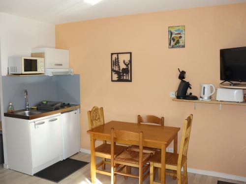 a kitchen and dining room with a table and a microwave at Appartement Studio in Prémanon