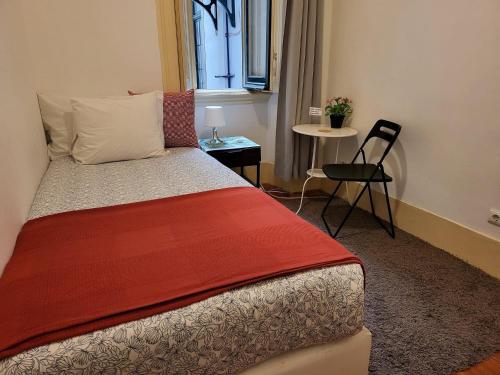 a bedroom with a bed and a table and a chair at PALMA 3 BEDROOM APARTMENTS-a in Lisbon