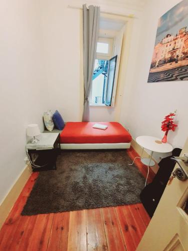 a small room with a red bed and a window at PALMA 3 BEDROOM APARTMENTS-a in Lisbon