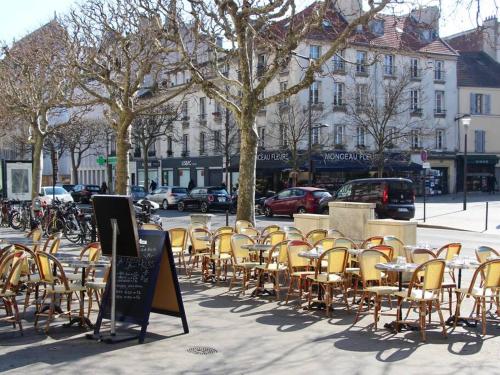 Une bande de chaises et de tables sur une rue de la ville dans l'établissement Paisible appartement aux portes de Paris, à Vincennes