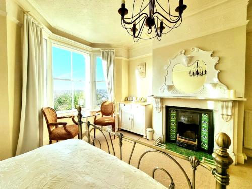 a bedroom with a bed and a fireplace at West Hill Retreat Edwardian Balcony Grand Ensuite with Room Served Breakfast & Free Offstreet Parking in Hastings