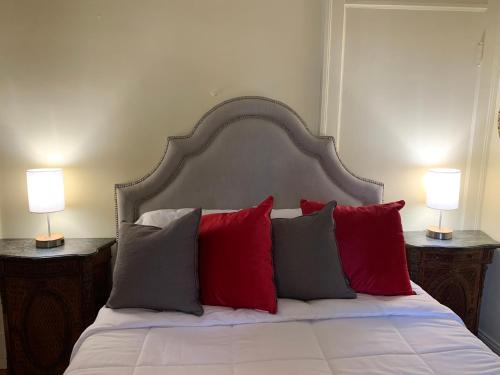 een bed met rode en grijze kussens en 2 lampen bij Sweet Apartment, next to Randolph College in Lynchburg