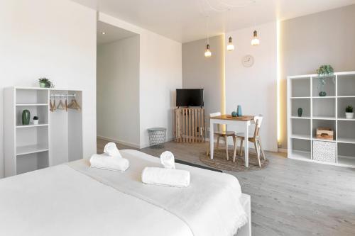 Biała sypialnia z 2 białymi łóżkami i stołem w obiekcie Calçada 14 w mieście Óbidos