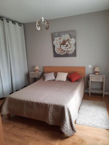 a bedroom with a bed and a flower on the wall at Gite de La Cheneraie in Montpezat-de-Quercy