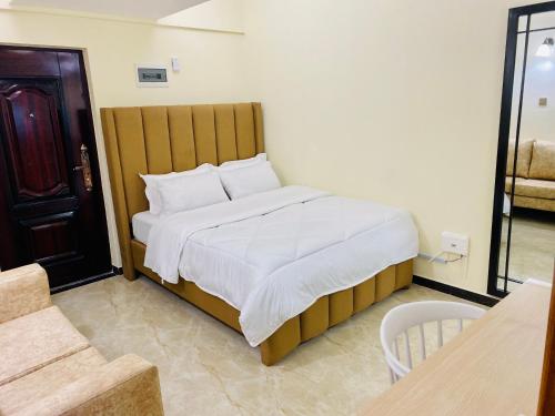 Schlafzimmer mit einem großen Bett mit einem Kopfteil aus Holz in der Unterkunft Dala Studio - Denis Pritt Road in Nairobi