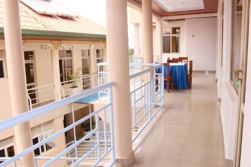 einen Balkon eines Gebäudes mit blauem Geländer und einem Tisch in der Unterkunft Fanad Hotel in Gisenyi
