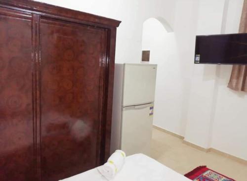 eine Küche mit einer Holztür und einem Kühlschrank in der Unterkunft The Magic of Luxor private studio apartment on the rooftop in Luxor
