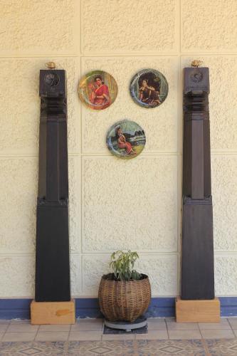 a wall with plates and a potted plant on it at Meeslu Mane, The Chic HomeStay in Hassan