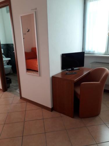 a room with a desk with a television and a chair at albergo del turista srl in Vernasca