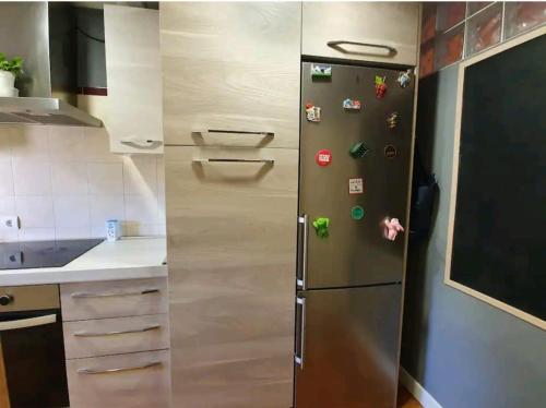 a refrigerator in a kitchen with magnets on it at Casa rural en la Sierra Norte de Madrid in Manjirón
