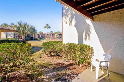 a white chair sitting on the side of a building at Beachwalk Condominiums 6F in Panama City Beach