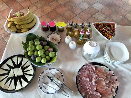 a table with plates of food and fruit on it at Agriturismo Bio Pian Dei Casali in Saturnia