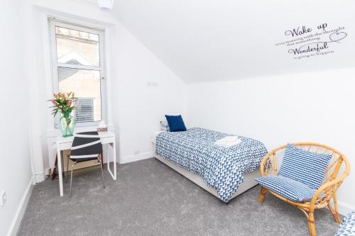 a bedroom with a bed and a table and a chair at Bridgeview in Dundee