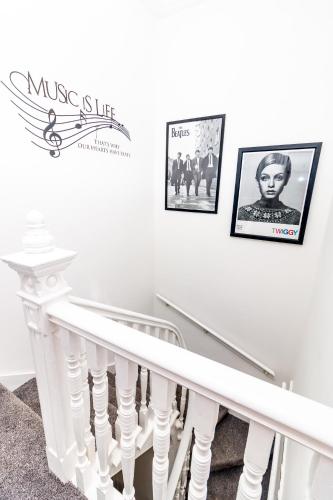 a white staircase with pictures on the wall at Bridgeview in Dundee