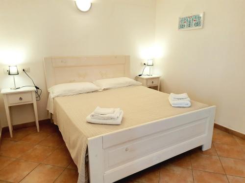 a bedroom with a white bed with towels on it at Agriturismo Orvile in Posada