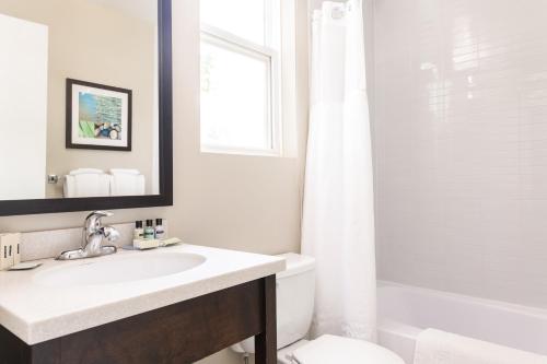 a white bathroom with a sink and a toilet at Rodd Royalty in Charlottetown