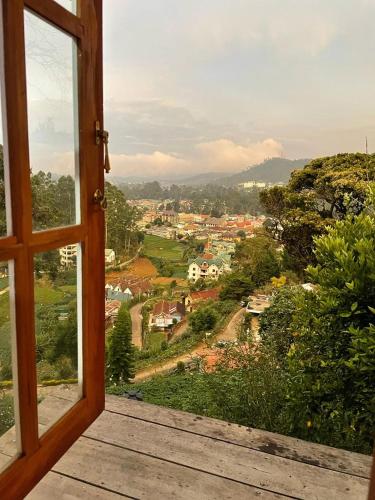 an open window with a view of a town at Sincere Wilderness Home stay in Nuwara Eliya