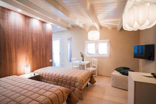 Habitación de hotel con 2 camas y sofá en Grantò B&B, en Gravina in Puglia