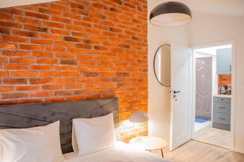 a red brick wall in a bedroom with a bed at Moon Hostel Warszawa in Warsaw