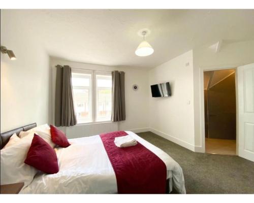 a bedroom with a bed with a red and white blanket at The Bitterne Park in Southampton