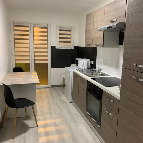 une cuisine avec une table et une chaise dans l'établissement Appartement 4 PERSONNES EMPLACEMENT IDEAL PROCHE DES 24H ET GARE, au Mans