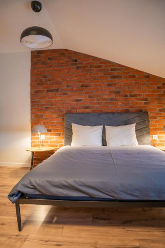 a bed in a room with a brick wall at Moon Hostel Warszawa in Warsaw