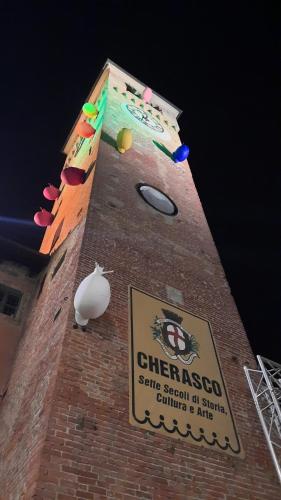 a tall brick tower with a sign on it at B&B Ai Tre Cavalli in Cherasco