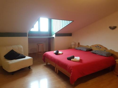 Un dormitorio con una gran cama roja y una silla en La Maison de Joséphine en Risoul